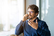 © Joao - Casual businessman wearing glasses talking on the phone. Successful male portrait at the office by the window