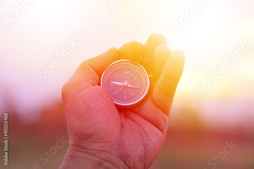 Close-up Of Hand Holding Compass Against Sky During Sunset © ekkawit sansra/EyeEm