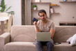 © Elnur - Young male freelancer holding wallet at home