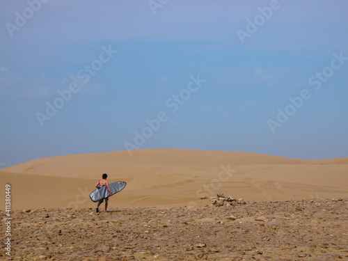 A Surfer Walking Through The Desert To Find Another Secret Spot