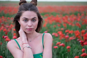 Wall Mural - close-up portrait of a young beautiful girl of European appearance walking in a poppy field, natural beauty. enjoying nature, having a good time.