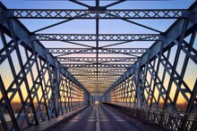 Diminishing View Of Metallic Bridge Against Sky During Sunset