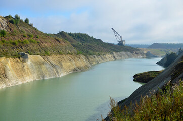 Wall Mural - Walking Dragline excavator in the chalk quarry near the village of Krasnoselsk, Volkovysk region, Republic of Belarus. Mountain lake or river with a turquoise or blue tint of water in a rock canyon.