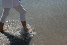 Low Section Of Woman Wading In Sea