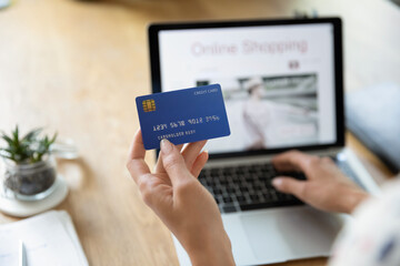 Close up back view of woman pay bills taxes online on laptop from home with credit card. Female buyer or client shopping making payment on computer using secure banking service system on device.