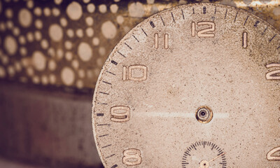 Vintage grunge background of an old clock. Abstract texture covered with dust, dirt, scratches. Macro photography in light tinted