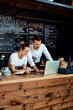 © baranq - Two restaurant cafe owners working with laptop behind the counter