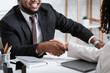 © Prostock-studio - Unrecognizable African American hiring manager shaking hand of vacancy candidate during employment interview at office