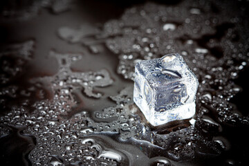 ice cubes reflection on black table background.