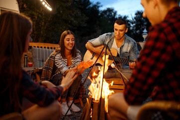 Wall Mural - friends playing on guitar by the bonfire, camping