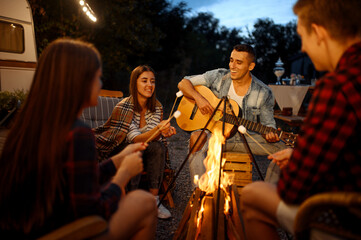 Wall Mural - friends playing on guitar by the bonfire, camping