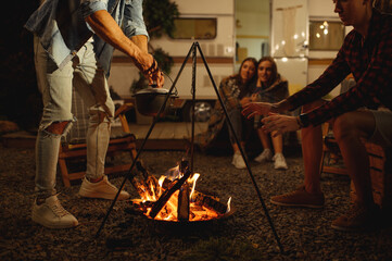 Wall Mural - friends warming themselves by campfire, camping