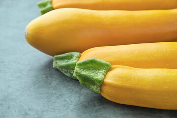 Four yellow zucchini on kitchen table. Whole raw courgettes