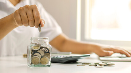 Wall Mural - Businessmen are putting coins in a savings jar, including growing penny for business, financial and accounting ideas.