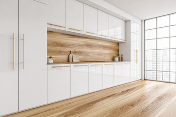 White and wooden kitchen set with appliances on parquet floor with window