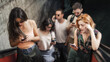 © guruXOX - Group of friends talk on smartphones while standing on escalator. Modern people with cell phones outdoor. Mobile communication technology. High angle view