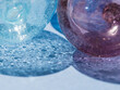 © Giovanna Graf - macro of transparent glass balls on light blue background with shadow, blue tones