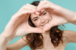 © ViDi Studio - Smiling bride young woman in beautiful white wedding dress showing shape heart with hands heart-shape sign isolated on blue turquoise background studio portrait. Ceremony celebration party concept.