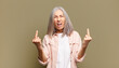 © kues1 - senior woman feeling provocative, aggressive and obscene, flipping the middle finger, with a rebellious attitude