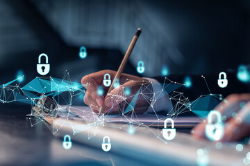 A programmer is taking notes of clients needs to protect cyber security from hacker attacks and save clients confidential data. Padlock Hologram icons over the typing hands. Formal wear