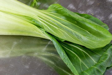 Pak Choi ist ein naher Verwandter des Chinakohls. Er bildet lockere Köpfe mit hellen Blattrippen. Die Blätter sind von dunklerem Grün, ähnlich denen des Mangolds