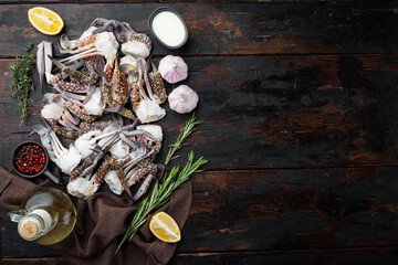 Fresh raw flower crab or blue crab parts, on dark wooden background, top view flat lay  , with copyspace  and space for text