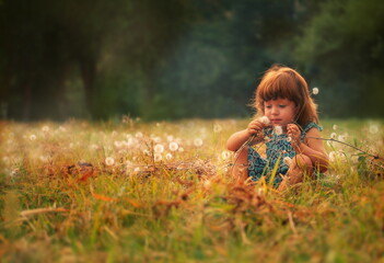 Little girl in the park holding a dandelion