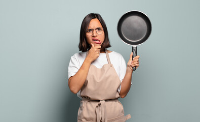 Canvas Print - young hispanic woman with mouth and eyes wide open and hand on chin, feeling unpleasantly shocked, saying what or wow