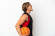 © luismolinero - Young blonde man holding a ball of basketball isolated on white background laughing in lateral position