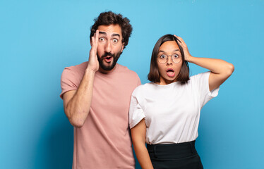 Canvas Print - young couple looking happy, astonished and surprised, smiling and realizing amazing and incredible good news