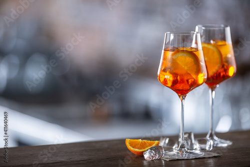 Typical summer sekt drink aperol spritz served in wine glass with aperol, prosecco, soda and a slice of orange © weyo