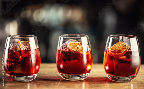Negroni classic cocktail and gin short drink with sweet vermouth, red bitter liqueur and dried orange garnish © weyo