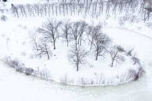 Aerial Of Winter Scenic With Bare Trees On Land, Surrounded By Water.