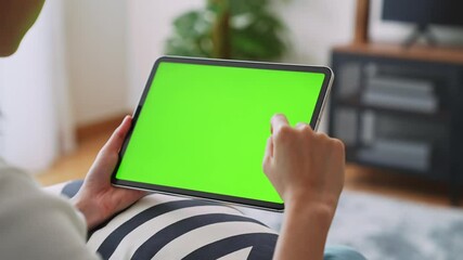 Wall Mural - Close up of woman holding in hands a digital tablet with green screen for internet online, chromakey screen for advertising.