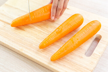 Wall Mural - Fresh carrot and cut pieces on wooden cutting board