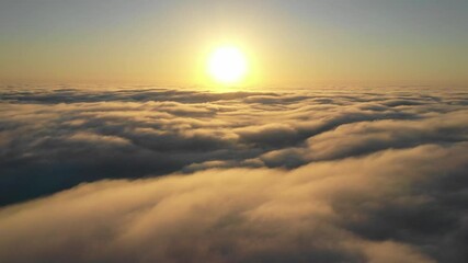 Wall Mural - striking aerial view of the sunset sky with the clouds below us. the shadows projected from the sun 
