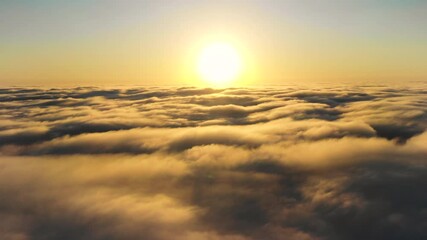 Wall Mural - striking aerial view of the sunset sky with the clouds below us. the shadows projected from the sun 