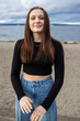 © Mat Hayward - Teenage girl outside at Alki Beach in West Seattle with a view of the Puget Sound and the city of Seattle in Washington State.