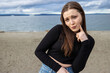 © Mat Hayward - Teenage girl outside at Alki Beach in West Seattle with a view of the Puget Sound and the city of Seattle in Washington State.