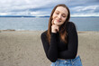 © Mat Hayward - Teenage girl outside at Alki Beach in West Seattle with a view of the Puget Sound and the city of Seattle in Washington State.