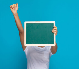 casual woman hiding behind green board and celebrating succes