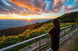 © Noppasinw - Tropical forest nature landscape view with woman toursit looking sunset mountain range at Doi Inthanon, Chiang Mai Thailand