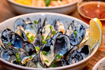 Delicious mussels in restaurant on a wooden table. Tasty seafood with beer in cafe or pub menu.