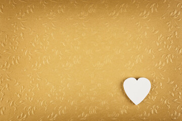 White heart on golden textured background. Valentines day card with copy space.