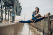 Japanese ballerina sitting in twine pose on the bridge.