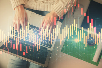 Double exposure of woman hands working on computer and forex chart hologram drawing. Top View. Financial analysis concept.