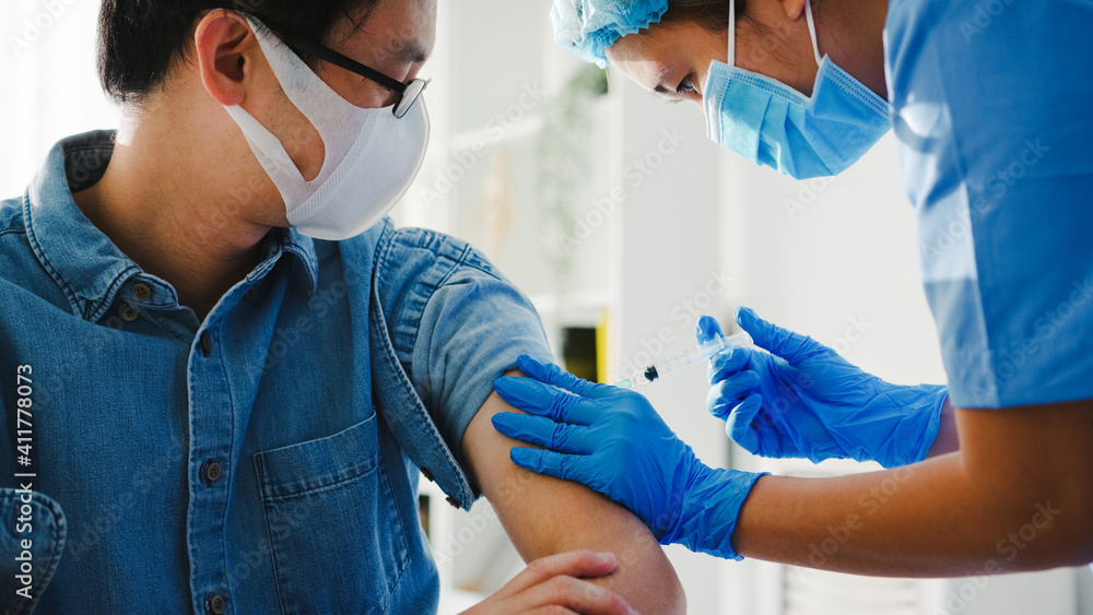 Young Asia lady nurse giving Covid-19 or flu antivirus vaccine shot to senior male patient wear face mask protection from virus disease at health clinic or hospital office. Vaccination concept. - obrazy, fototapety, plakaty 
