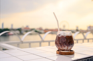 Chilled iced chocolate cocoa in glasses with tubes for drinking on the balcony by the river. Copy space