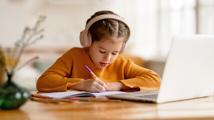 Canvas Print - Focused girl making notes during remote education