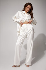 sexy brunette woman luxury lifestyle bright makeup wear natural organic white silk suit pants blouse